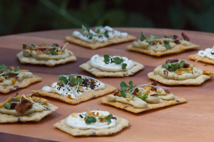 Crackers topped with herbed cream cheese and microgreens